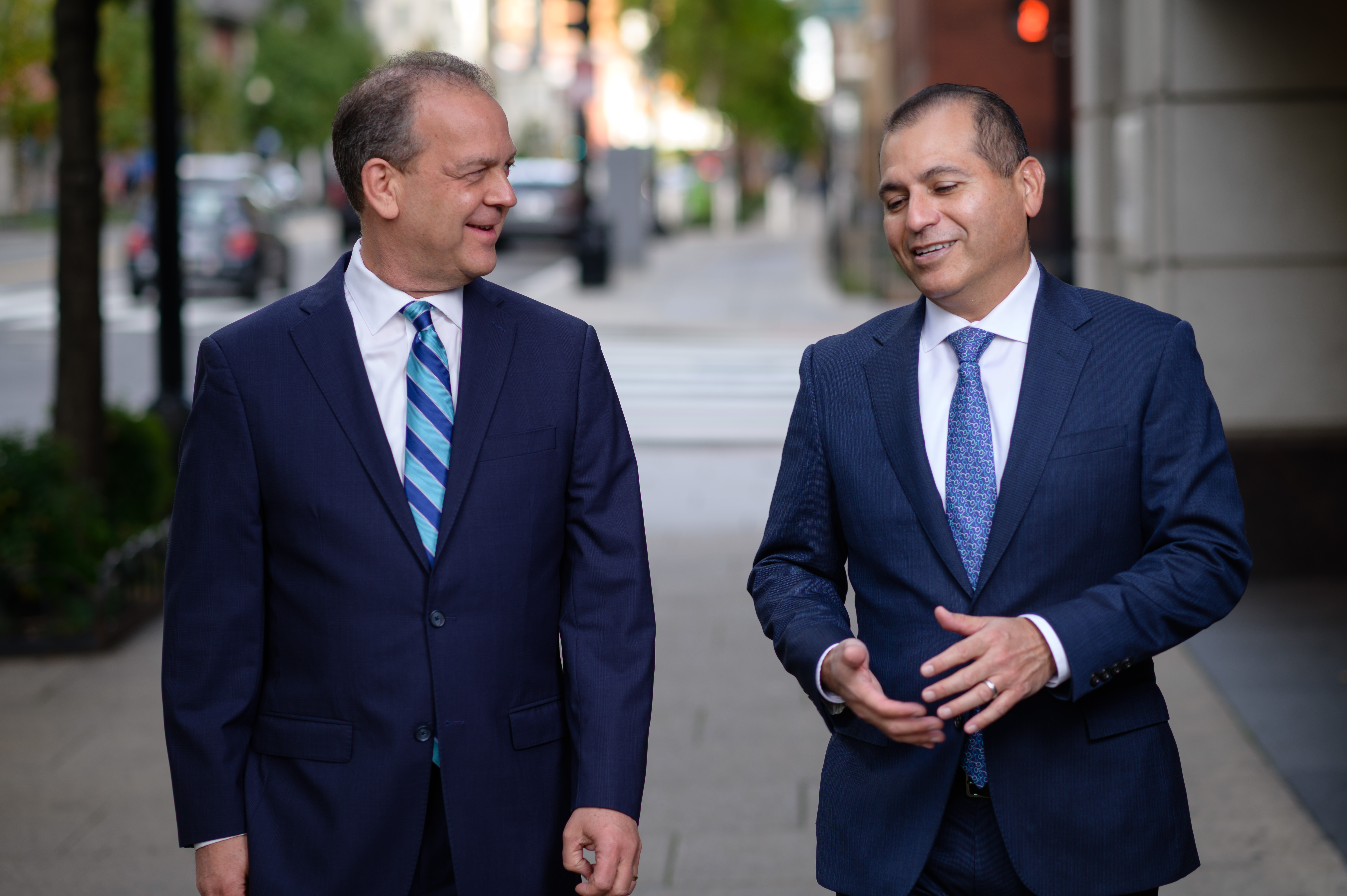 Daniel A. Nissenbaum and Reymundo Ocañas talking together while walking down the street.