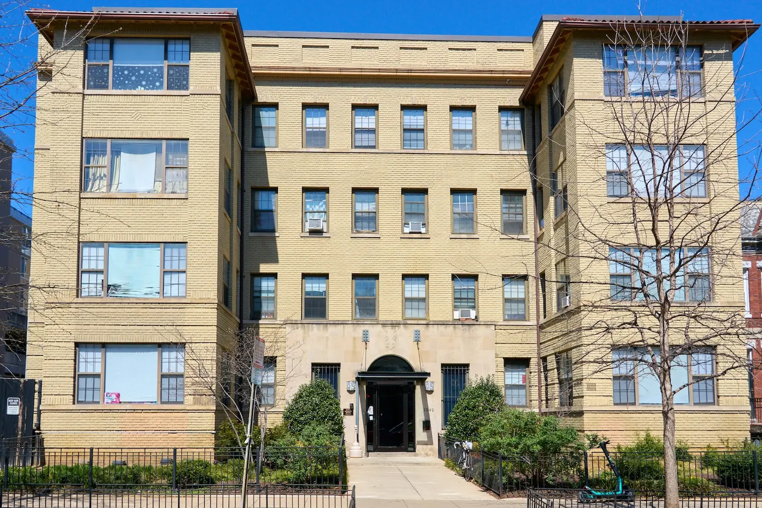 A brick apartment building with an inviting front entrance.